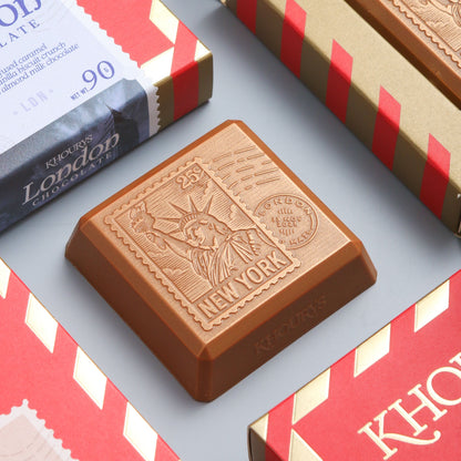 Khoury's chocolate bars with red and gold packaging on a light gray background