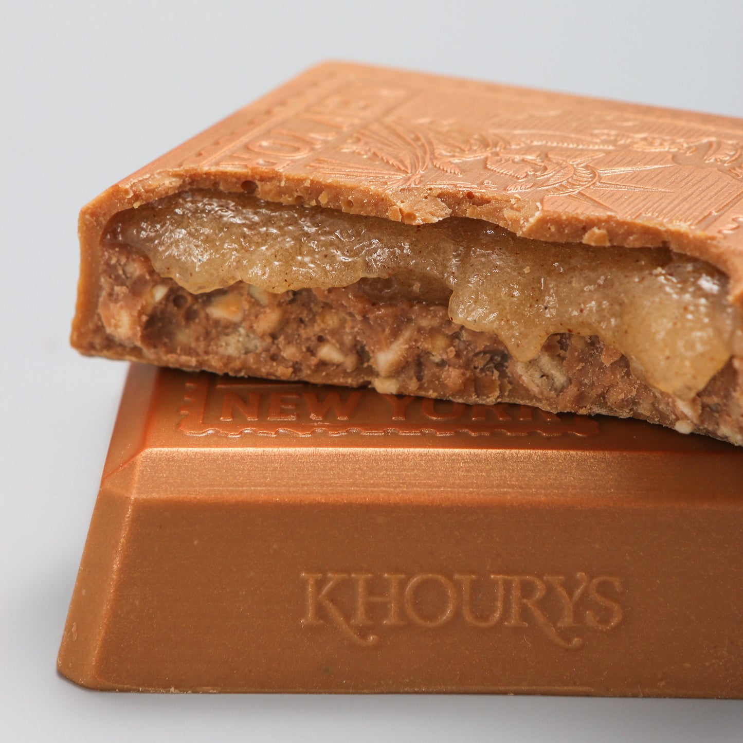 Close-up of a chocolate bar with 'Khoury's' branding on a light gray background