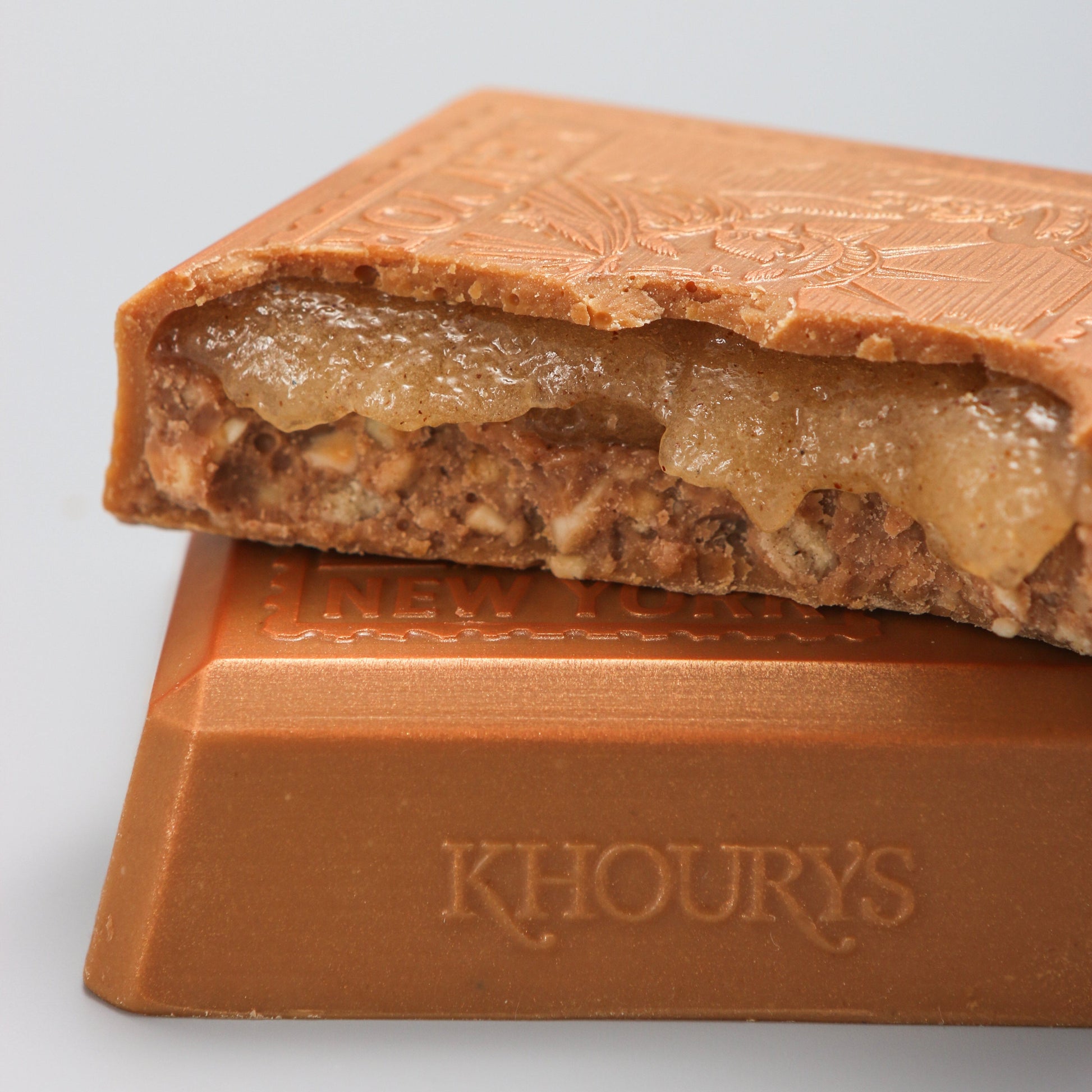 Close-up of a chocolate bar with 'Khoury's' branding on a light gray background